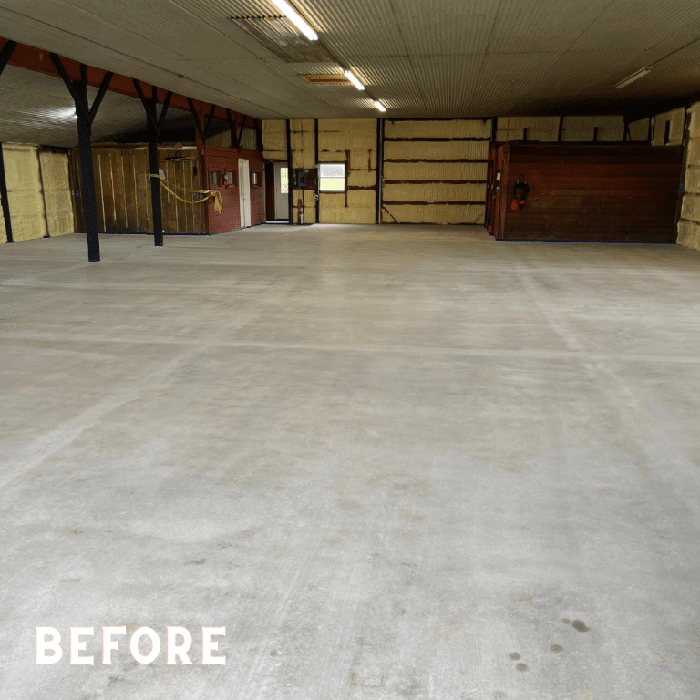 Image of a garage floor with stains, cracks, and other damages. The surface is rough and uneven, and requires an upgrade with a durable and attractive flooring solution.